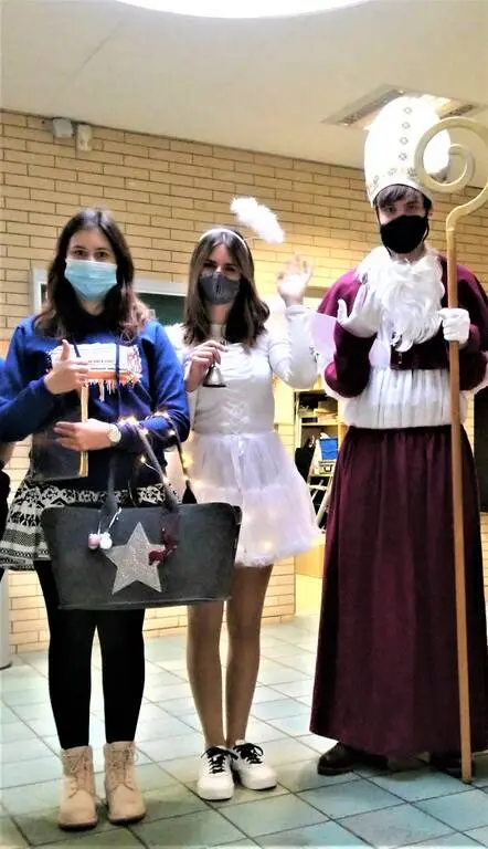 Zwei Schülerinnen und eine als Nikolaus verkleidete Person mit Engelskostüm