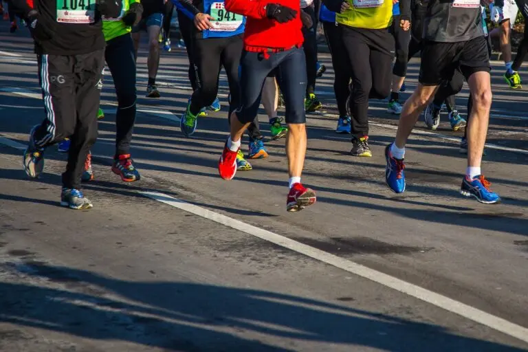 Beine und Laufschuhe zahlreicher Läuferinnen und Läufer bei einem Lauf auf Asphalt