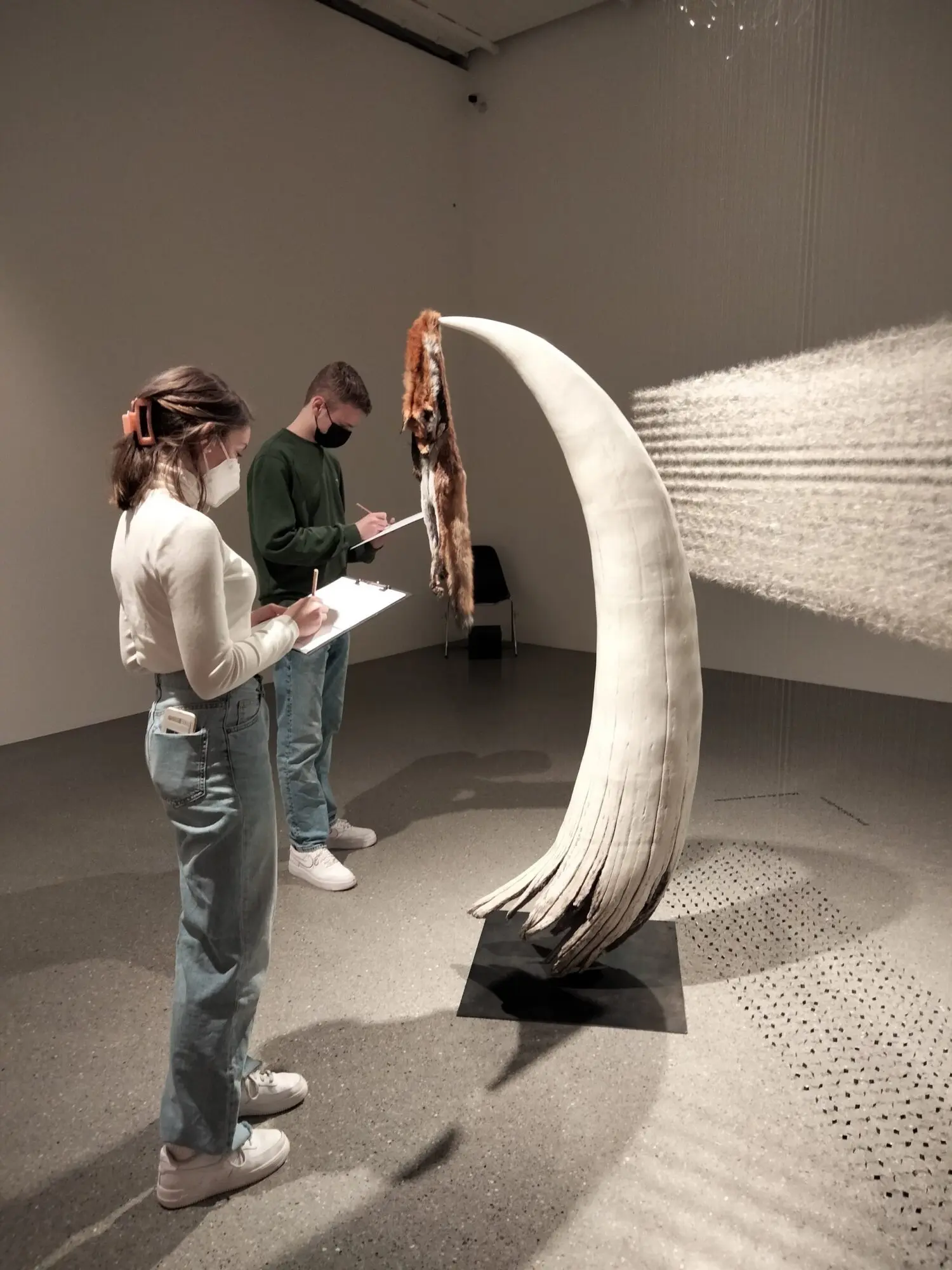Schülerinnen betrachten eine geschwungene weiße Skulptur in einem Ausstellungsraum