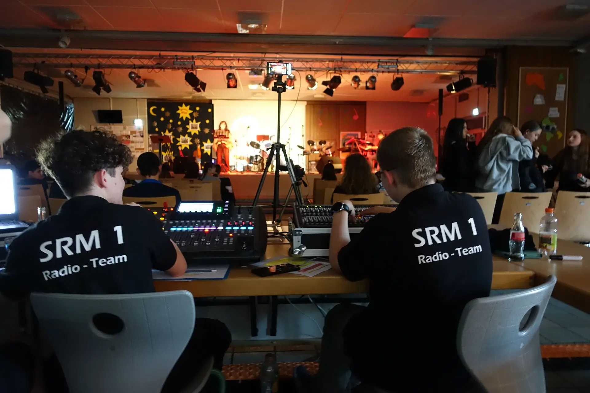 Zwei Schüler in T-Shirts „SRM 1“ an der Technik im Zuschauerraum eines Konzerts