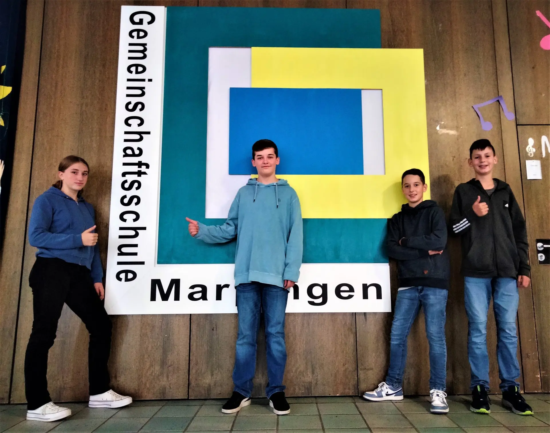 Vier Schüler stehen vor einem großen Schild „Gemeinschaftsschule Marpingen“