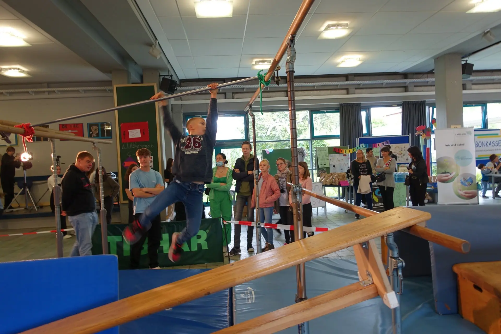Besucher an Spiel- und Bewegungsstationen in einer Halle beim Schulfest