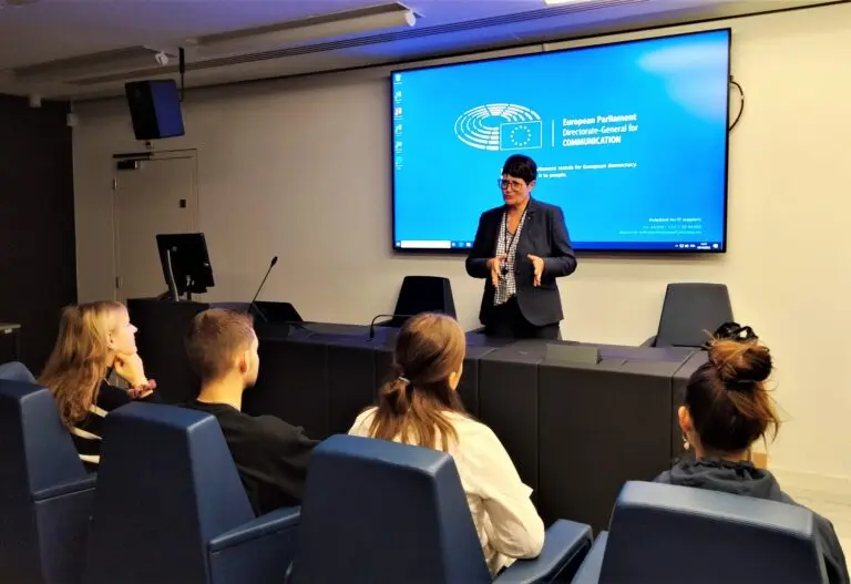 Rednerin vor Schülerinnen und Schülern in einem Saal mit Bildschirm des Europäischen Parlaments