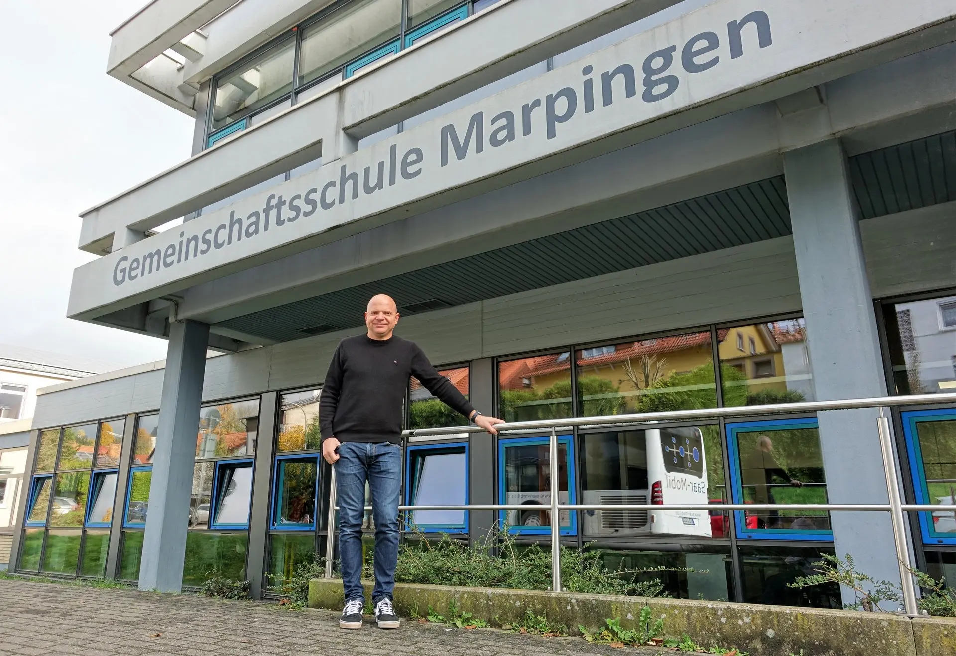 Mann steht vor dem Gebäude mit der Aufschrift „Gemeinschaftsschule Marpingen“