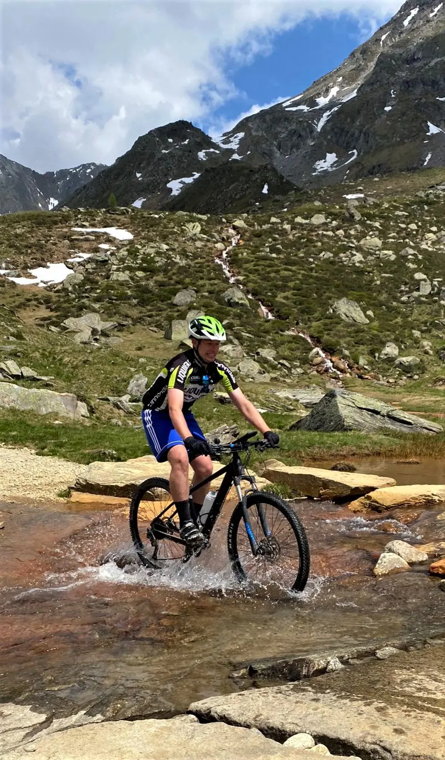 Jugendlicher fährt mit dem Mountainbike über einen felsigen Pfad im Hochgebirge