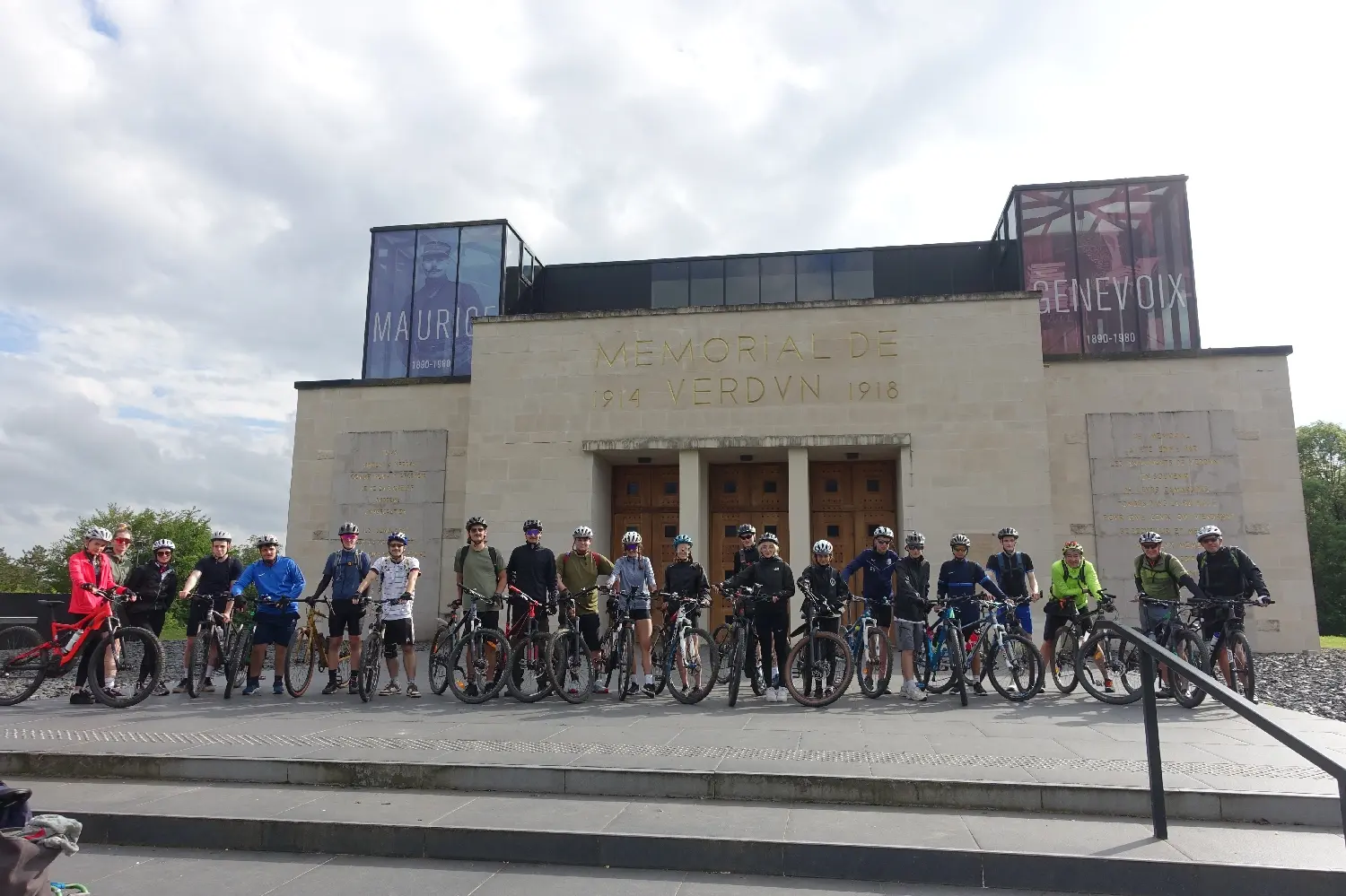 Große Radfahrergruppe auf einer Treppe vor einem modernen Gebäude