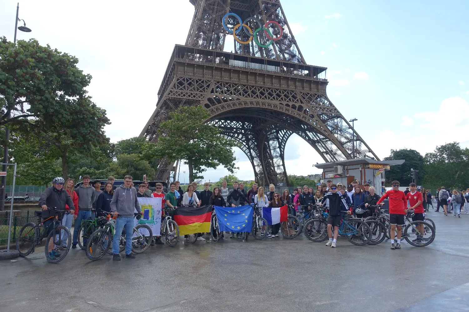 Radfahrergruppe mit Deutschland- und Europafahne vor dem Eiffelturm