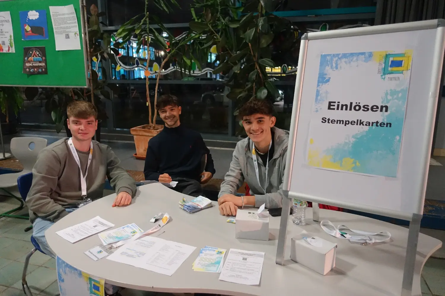 Schüler sitzen an einem Tisch mit Schild „Einlösen Stempelkarten“