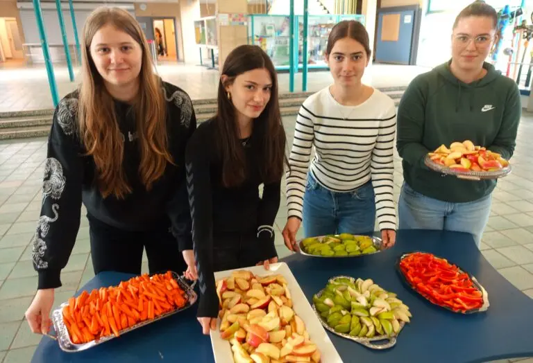 Schülerinnen und Schüler präsentieren Platten mit geschnittenem Obst und Gemüse