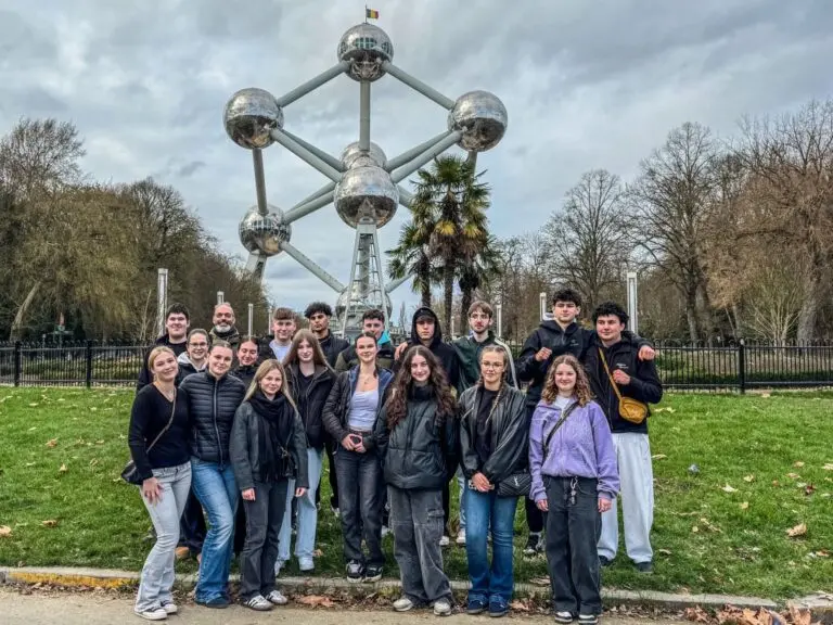 Schülergruppe steht auf einer Wiese vor dem Atomium in Brüssel