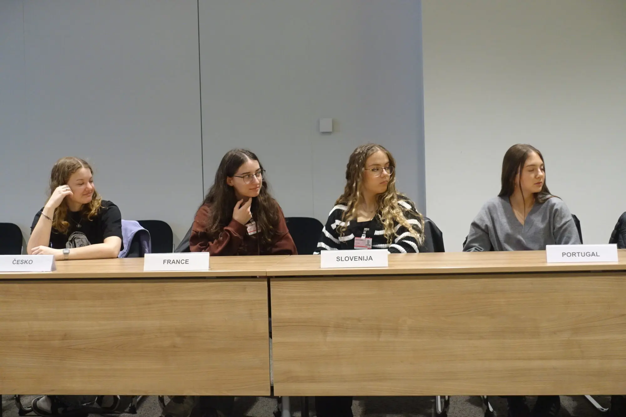 Vier junge Frauen sitzen an einem Podiumstisch mit Namensschildern in einem Konferenzraum