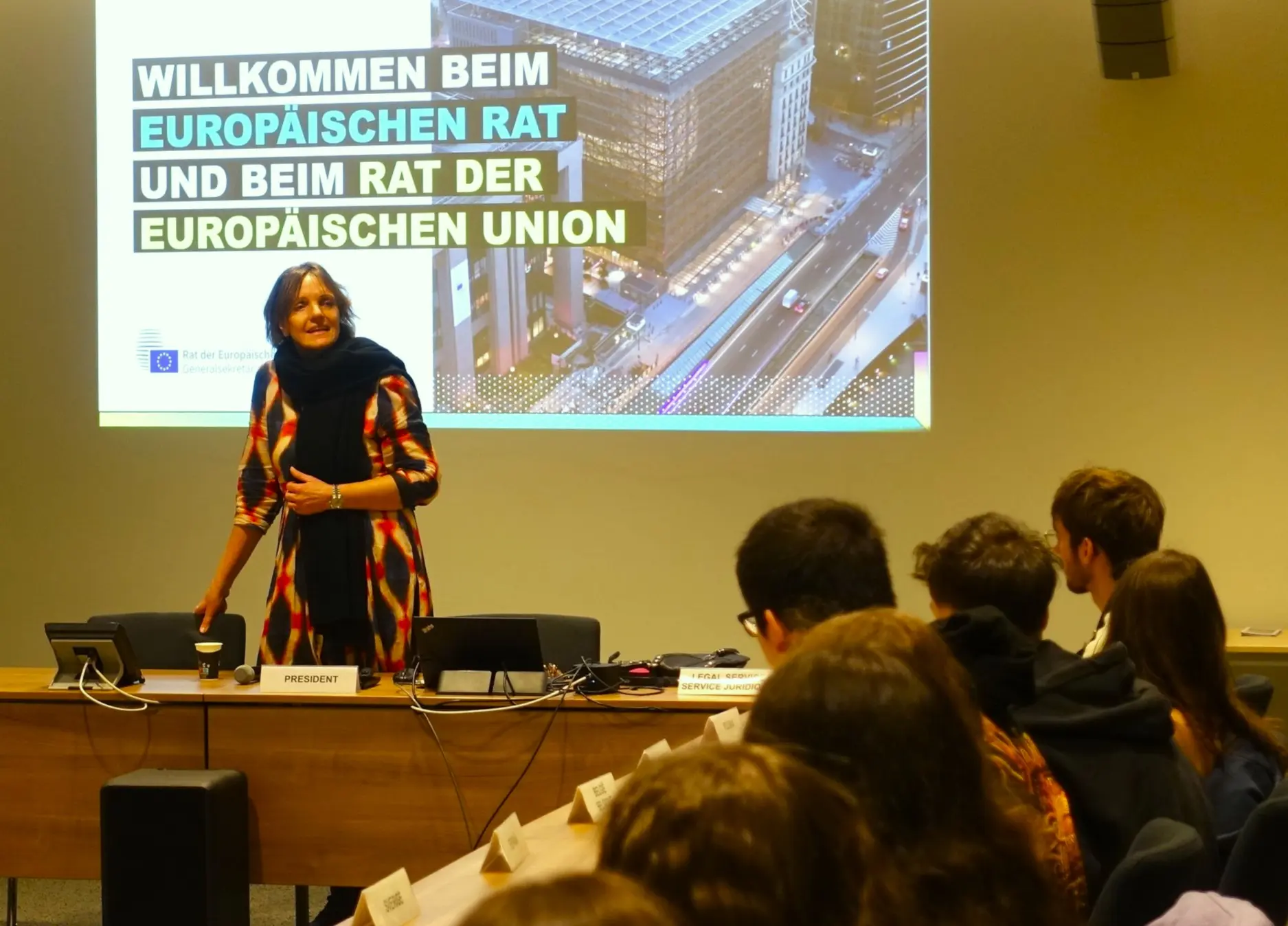 Referentin vor Leinwand mit „Willkommen beim Europäischen Rat und beim Rat der Europäischen Union“, Schüler hören zu