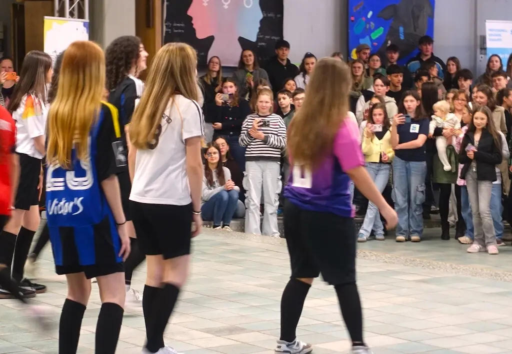Schülerinnen in Sportkleidung bei einer Tanzvorführung vor Publikum in der Halle