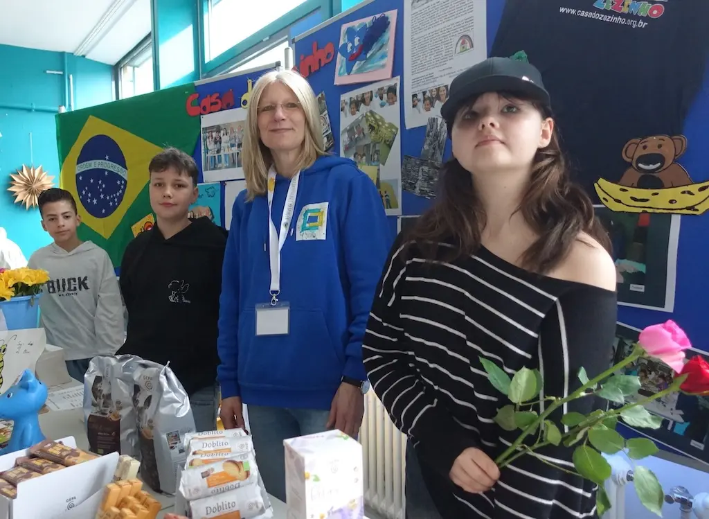Schülerinnen und Schüler stehen an einem Verkaufsstand mit Blumen und Dekoration