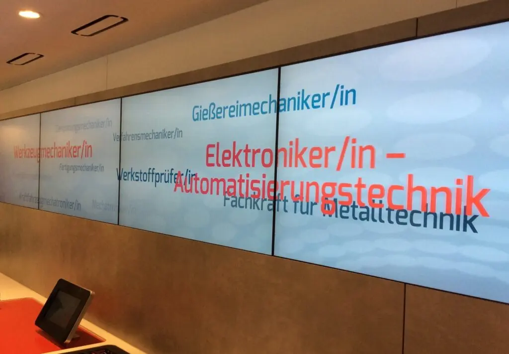 Bildschirmwand in einem Infotruck nennt Berufe wie Elektroniker/in für Automatisierungstechnik und Gießereimechaniker/in