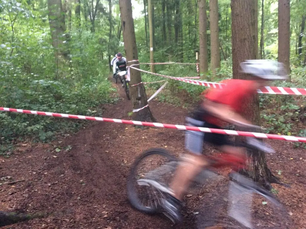Mountainbiker fährt auf einem abgesperrten Waldweg durch den Wald