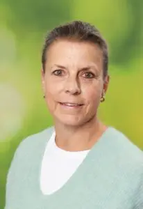 Porträt Tanja Hameister, mit kurzen Haaren im mintfarbenen Pullover vor grünem Hintergrund