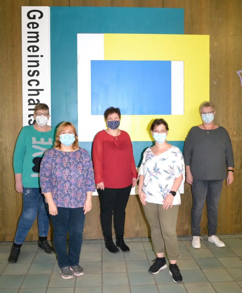 Fünf Frauen des Reinigungsteams mit Mund-Nasen-Masken im Eingangsbereich der Gemeinschaftsschule
