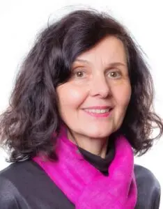 Porträt Helene Hoffmann-Dewes, mit dunklen lockigen Haaren und pinkem Schal vor weißem Hintergrund